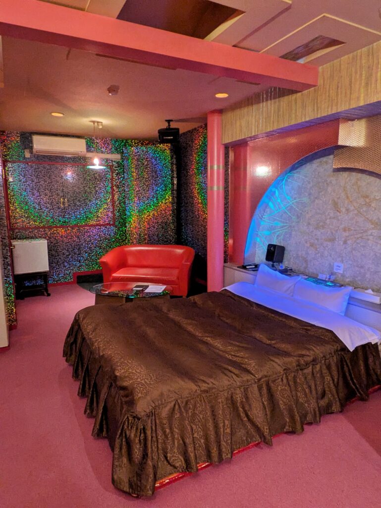 Hotel ARUN 網走客房全景:結合霓虹燈光、復古沙發與寬敞床鋪的昭和摩登空間