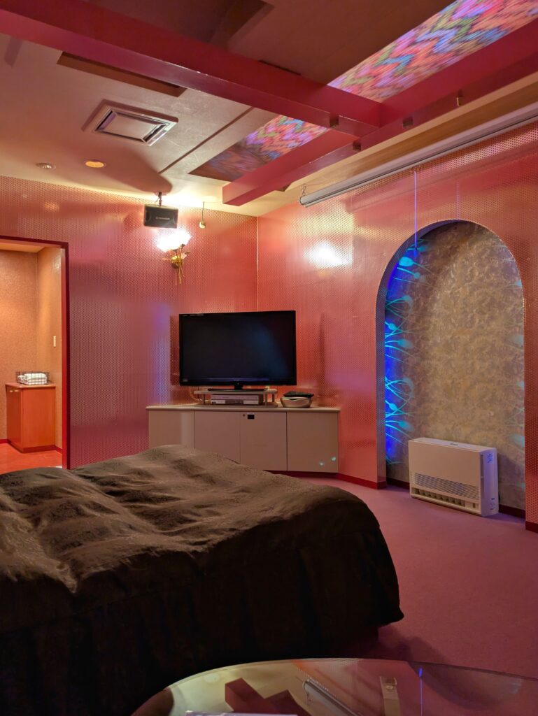 Hotel ARUN 網走客房設計:紅粉色系霓虹燈光、拱形裝潢與床鋪全景