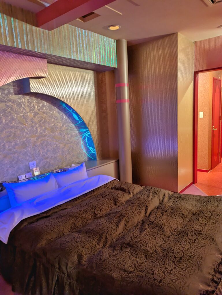 Hotel ARUN 客房空間:金色金屬質感牆面、寬敞雙人床與粉色地毯