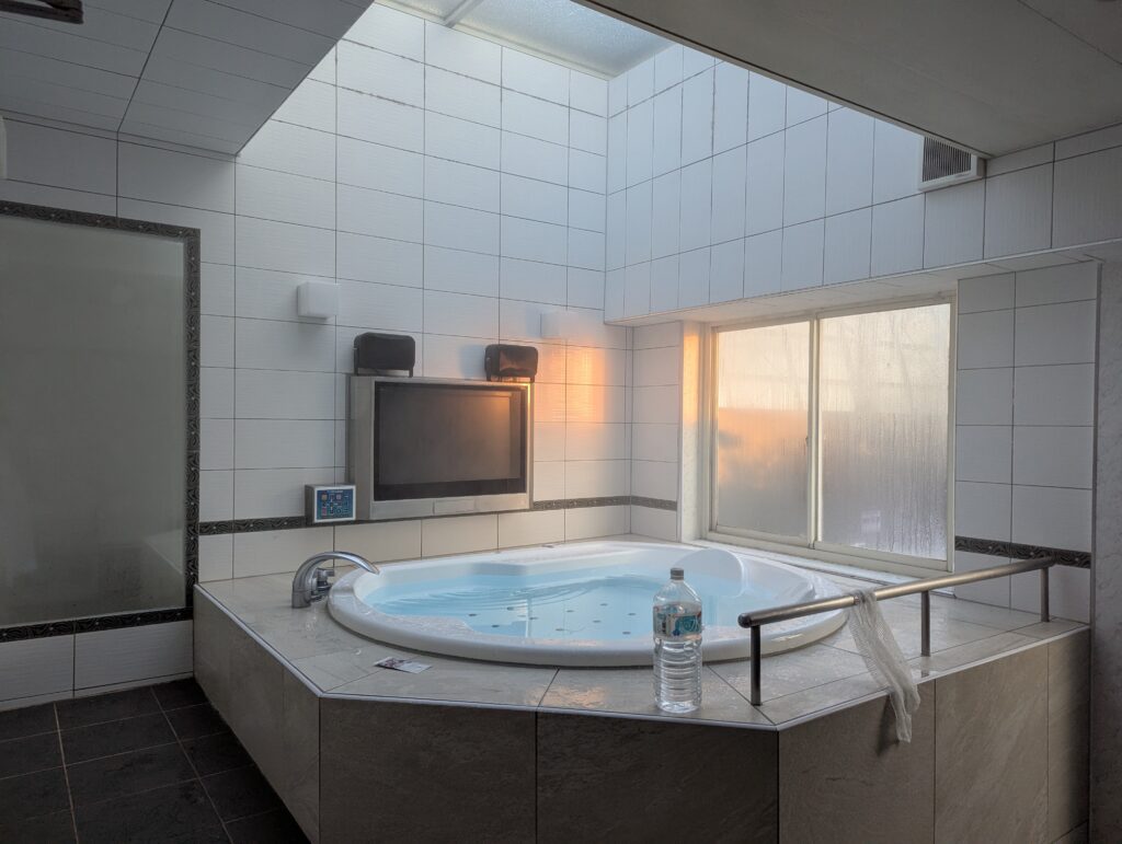 朝の光が差し込むHOTEL LUNA町田店 501号室の内風呂。天井の採光窓と大きな窓から心地よい朝日が入り、夜とは一転して明るく爽やかな雰囲気のジャグジー風呂。